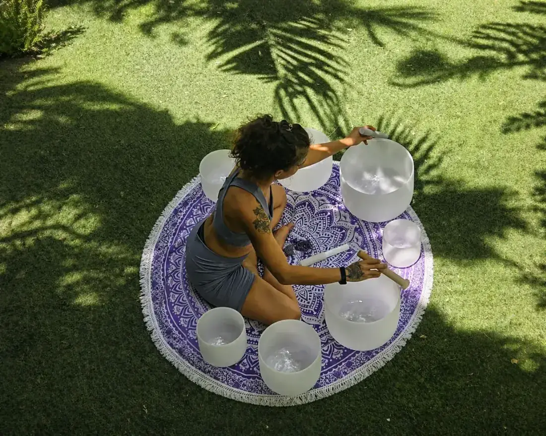 Brass singing bowls with quartz crystals on a linen surface for sound healing